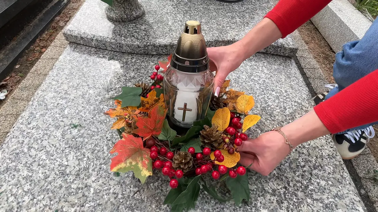 Ustawianie gotowego domowego stroika ze zniczem na płycie nagrobka