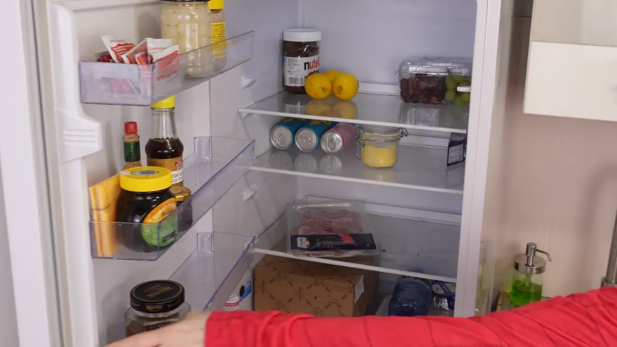 Otwarta lodówka w kuchni z produktami spożywczymi na półkach